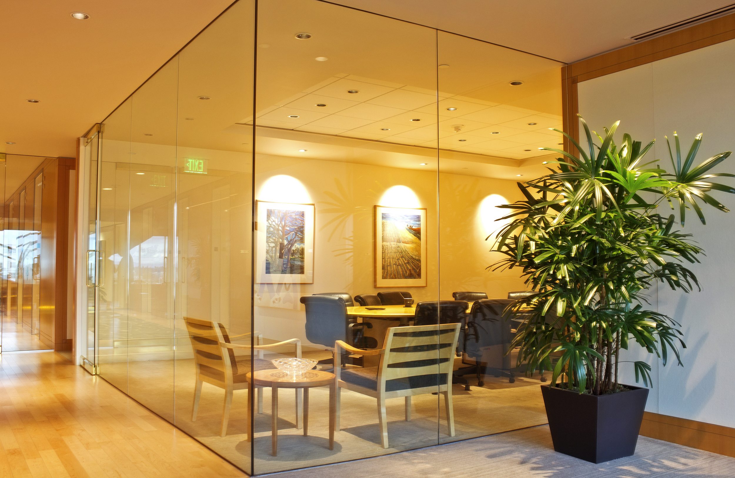 A luxurious meeting room enclosed in glass within a corporate office.