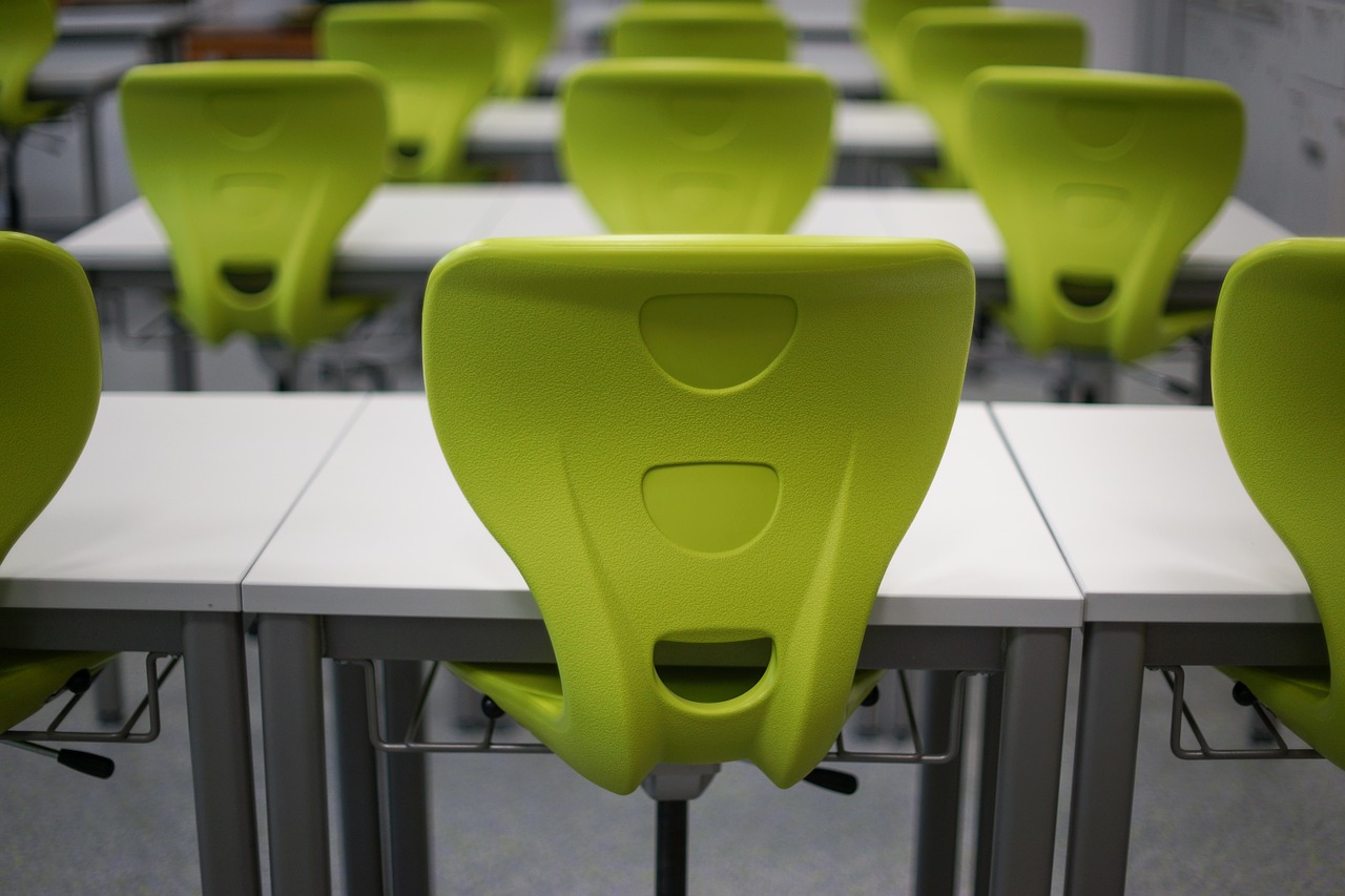 A selection of desks and chairs present in a classroom or conference room.